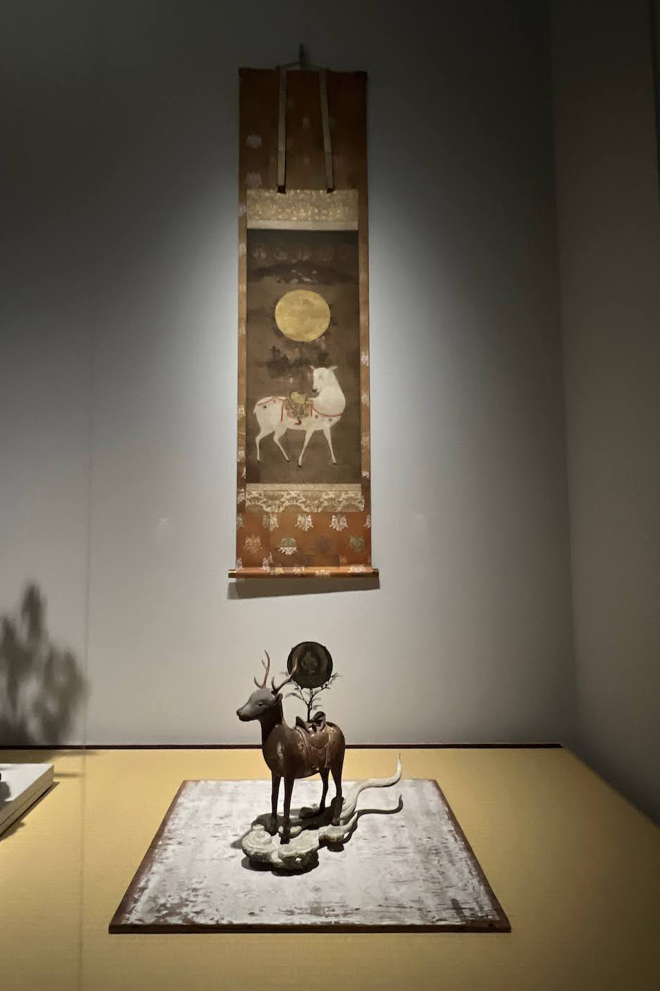 手前 ≪春日若宮神鹿像≫ (鎌倉時代、角、鞍、榊、雲 補作：須田悦弘)、奥 ≪春日鹿曼荼羅≫ (室町時代、杉本表具)